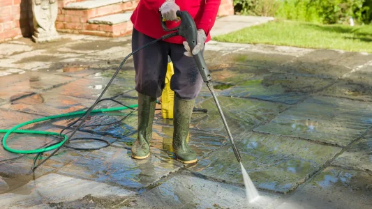 person-pressure-washing-patio-house-1359541598